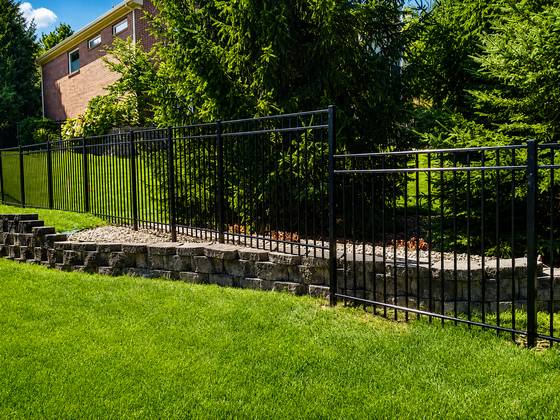 Black ornamental aluminum along a retaining wall