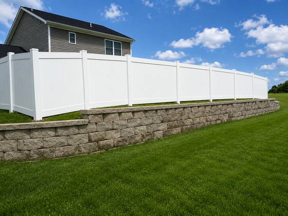 White vinyl privacy above a retaining wall